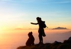 Girl plays with his dog in the mountain