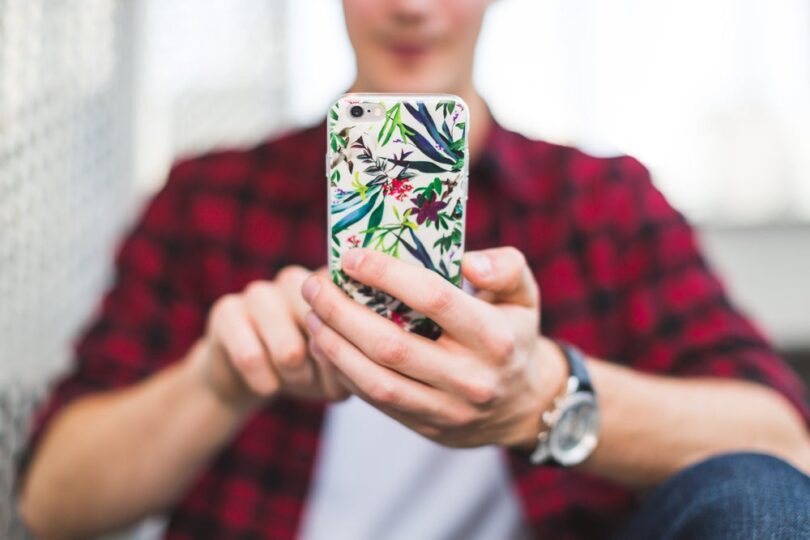 Young man texting on iphone